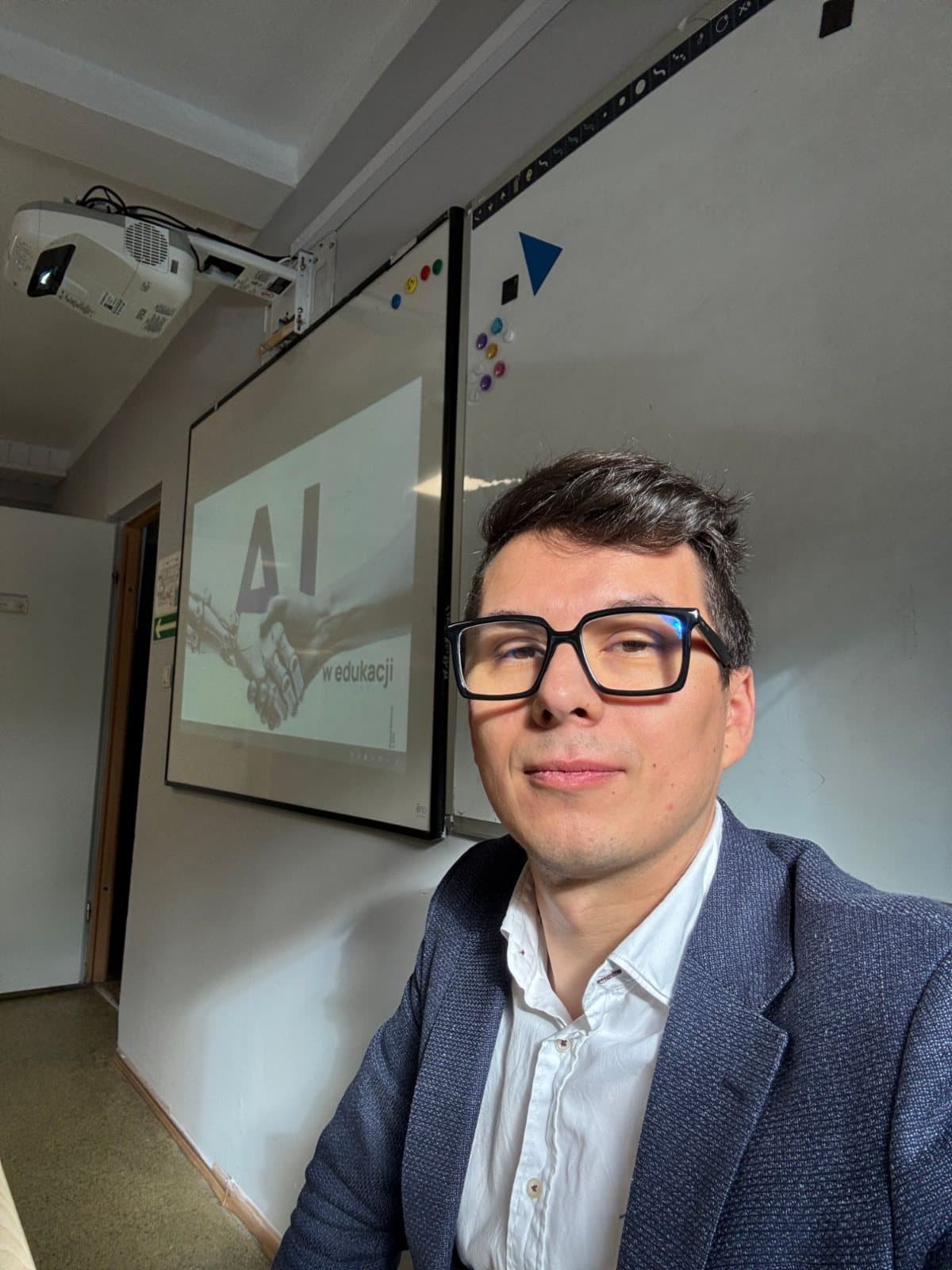 Przemek Blicharski in a training room, in front of a slide about AI
